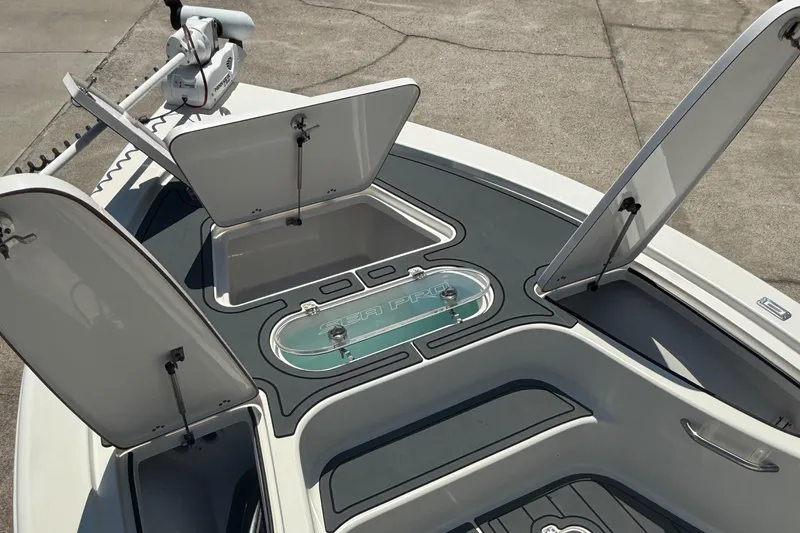 Slide: The Image of 2021 Sea Pro 248 Bay boat deck with open storage compartments and livewell. - 6