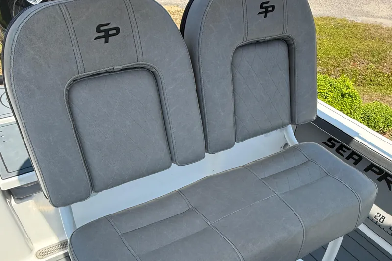 Slide: The Image of 2021 Sea Pro 248 Bay boat seats with gray upholstery and embroidered logo. - 7