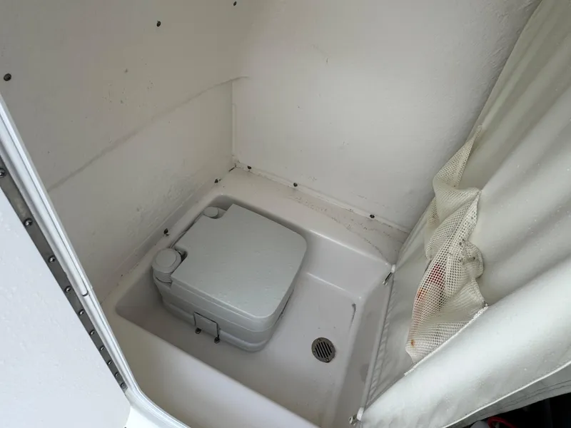 Slide: The Image of 2016 Tidewater 230 LXF boat interior with portable toilet and curtain. - 15