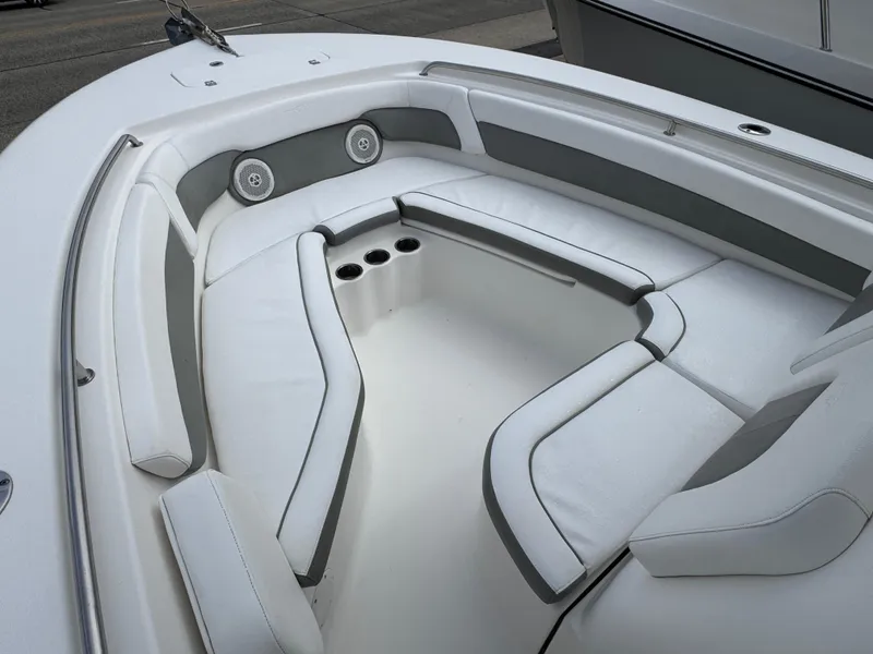 Slide: The Image of 2016 Tidewater 230 LXF boat interior with white cushioned seating and cup holders. - 16