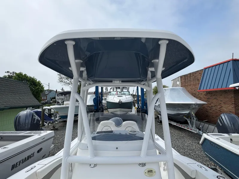 Slide: The Image of 2016 Tidewater 230 LXF boat with T-top, parked among other boats in a marina. - 18