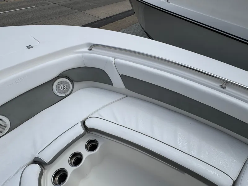 Slide: The Image of 2016 Tidewater 230 LXF boat interior with white cushioned seating and built-in speakers. - 19