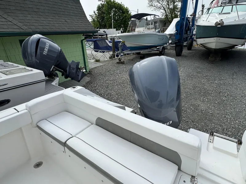 Slide: The Image of 2016 Tidewater 230 LXF boat with dual Yamaha outboard motors in a marina setting. - 3