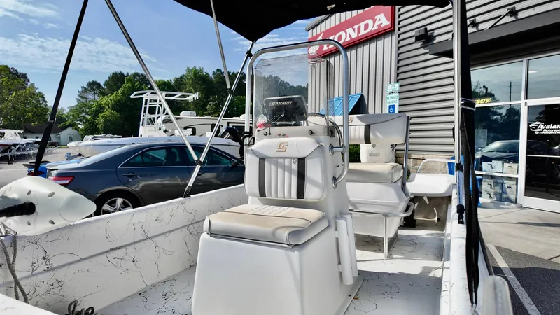 Slide: The Image of 2008 Carolina Skiff 16 DLX boat with seating, parked near a Honda dealership. - 10