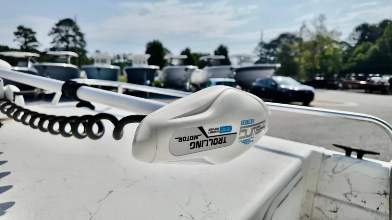 Slide: The Image of Trolling motor on 2008 Carolina Skiff 16 DLX boat, outdoor setting with trees and vehicles. - 16