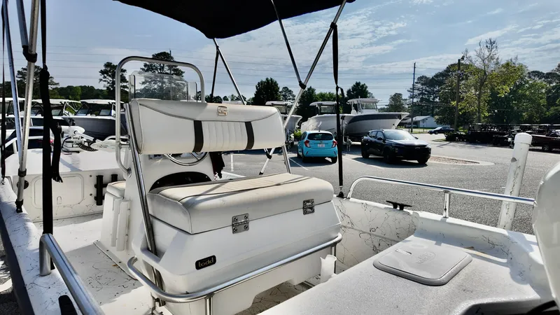 Slide: The Image of 2008 Carolina Skiff 16 DLX boat interior with seating and canopy in a parking lot. - 3