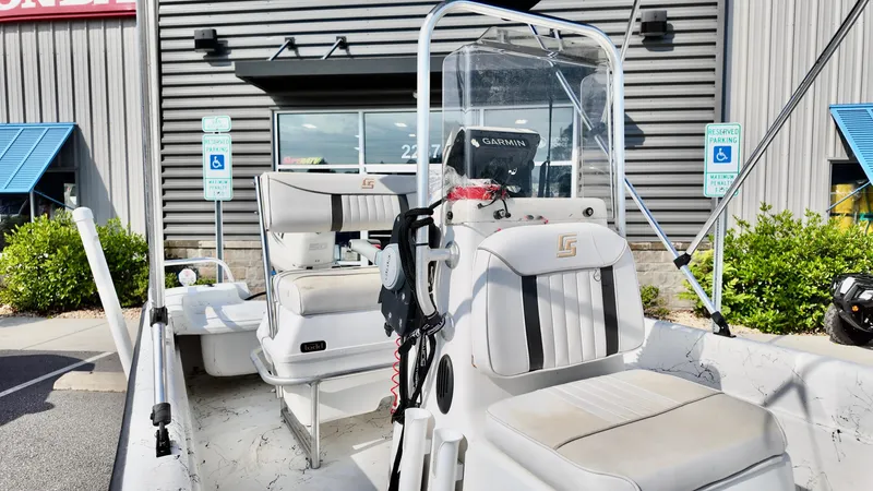 Slide: The Image of 2008 Carolina Skiff 16 DLX boat with seating and console, parked outside a building. - 5