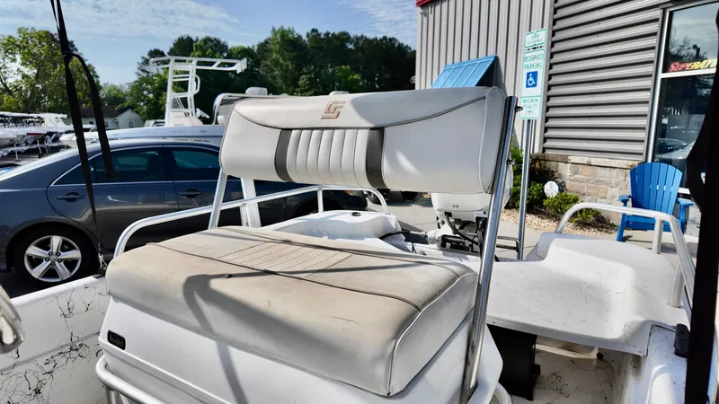 Slide: The Image of 2008 Carolina Skiff 16 DLX boat seat, outdoor setting, parked near vehicles and building. - 9