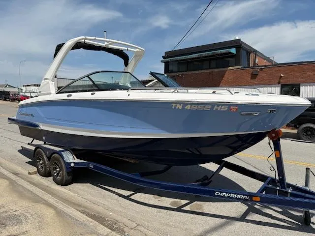 Slide: The Image of 2023 Chaparral 267 SSX boat on trailer, parked on street, sunny day. - 0