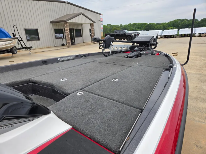 Slide: The Image of 2022 Skeeter FXR 20 Limited boat, featuring spacious deck and modern design, parked outdoors. - 6