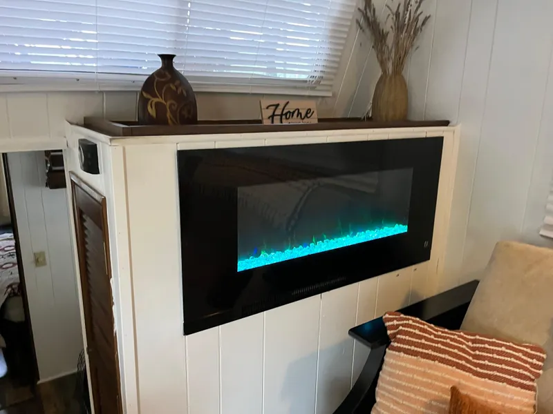 Slide: The Image of Modern electric fireplace with decorative vases and "Home" sign on top. - 11