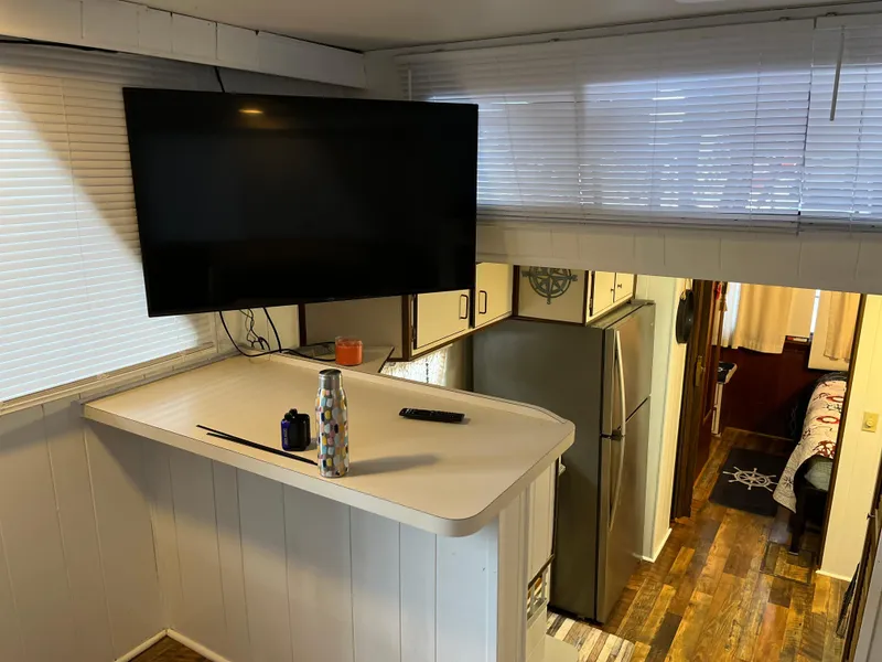 Slide: The Image of Modern kitchen area in a 1988 Gibson Standard boat with TV and appliances. - 15