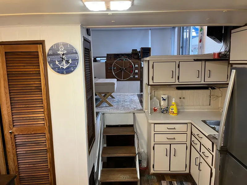 Slide: The Image of 1988 Gibson Standard boat interior with kitchen, stairs, and nautical decor. - 16