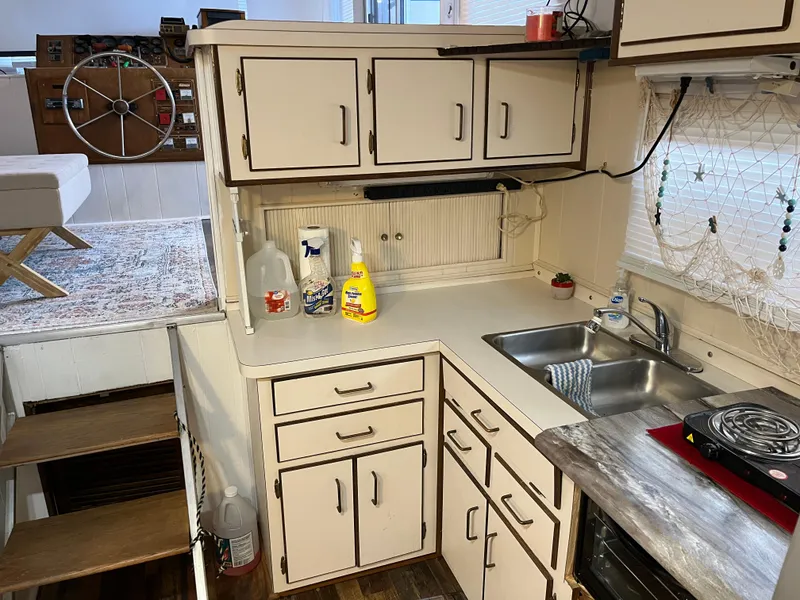 Slide: The Image of Cozy kitchen in a 1988 Gibson Standard boat with white cabinets and compact appliances. - 17