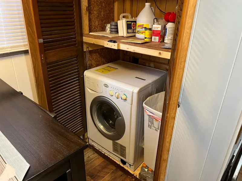 Slide: The Image of Compact laundry area with a front-loading washing machine and cleaning supplies on a shelf. - 19