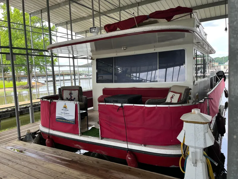 Slide: The Image of 1988 Gibson Standard houseboat docked, featuring red accents and covered seating area. - 2