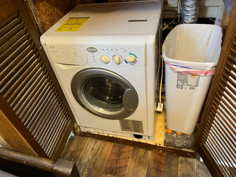 Slide: The Image of Front-loading washing machine in a compact laundry space with a trash bin nearby. - 20