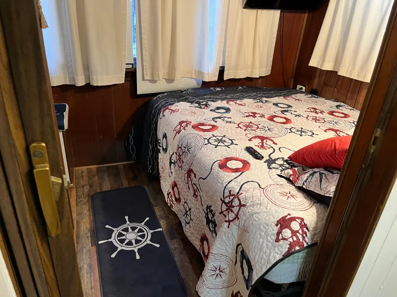 Slide: The Image of Cozy bedroom with nautical-themed bedding and decor, featuring a ship wheel rug and wooden walls. - 22
