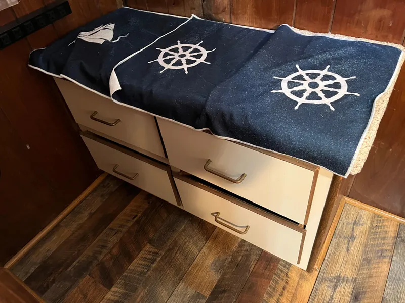 Slide: The Image of Wooden drawers with nautical-themed covers, featuring ship wheels, on a wooden floor. - 25