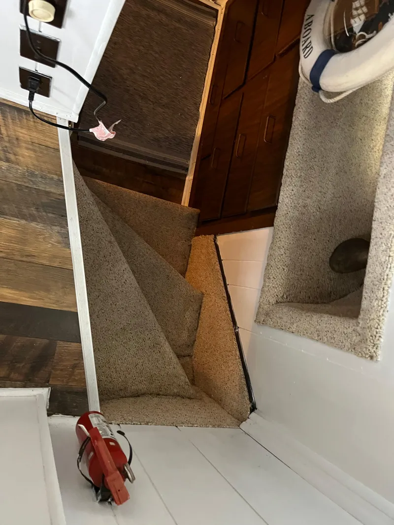 Slide: The Image of Narrow carpeted stairs in a cozy interior with wooden accents and a life preserver. - 34