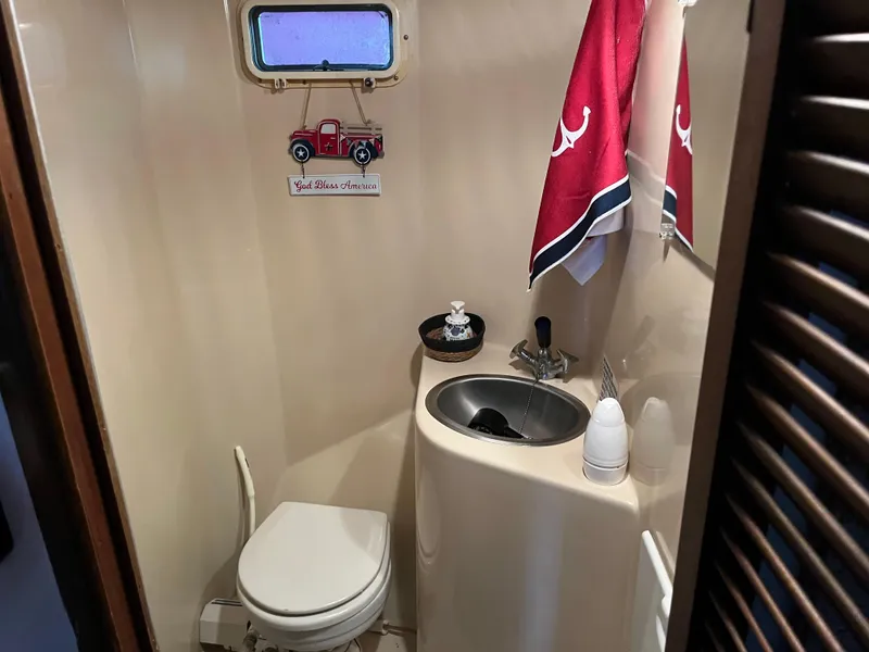 Slide: The Image of Small boat bathroom with sink, toilet, red towels, and vintage decor. - 39