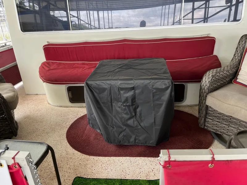 Slide: The Image of Cozy boat interior with red seating, covered table, and wicker chair, Gibson Standard 1988. - 4