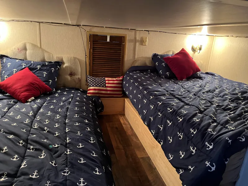 Slide: The Image of Two cozy beds with nautical-themed bedding and decorative pillows in a Gibson Standard 1988. - 40