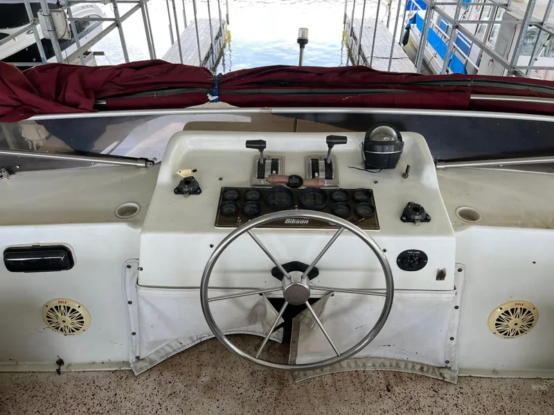 Slide: The Image of 1988 Gibson Standard boat helm with steering wheel and control panel at dock. - 7