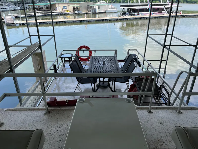 Slide: The Image of Houseboat deck with table, chairs, and life preserver on a calm waterfront. - 8