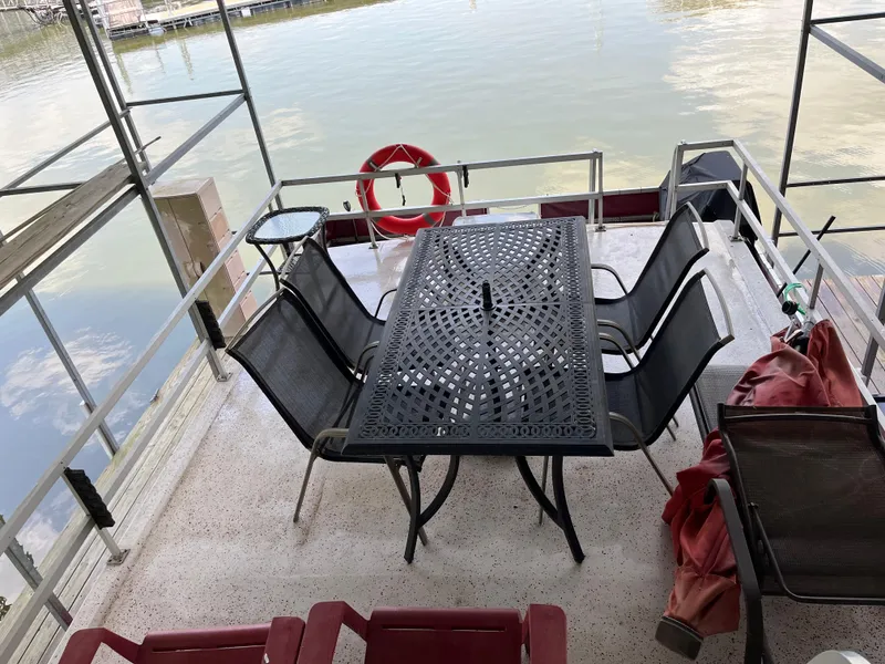 Slide: The Image of Outdoor deck with metal table, chairs, and life preserver overlooking water. - 9