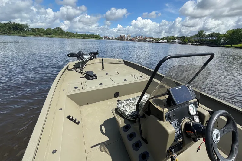 Slide: The Image of 2024 Tracker Grizzly 2072 SC boat on a calm river under a partly cloudy sky. - 7