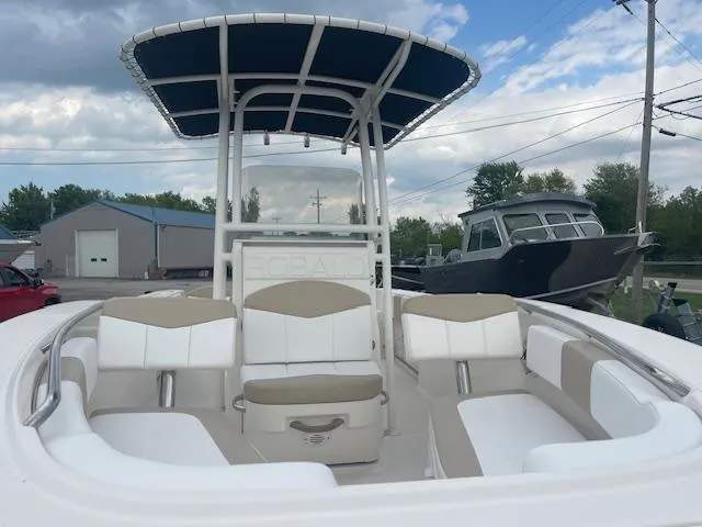 Slide: The Image of 2017 Robalo R200 Center Console boat with seating and T-top under a cloudy sky. - 2