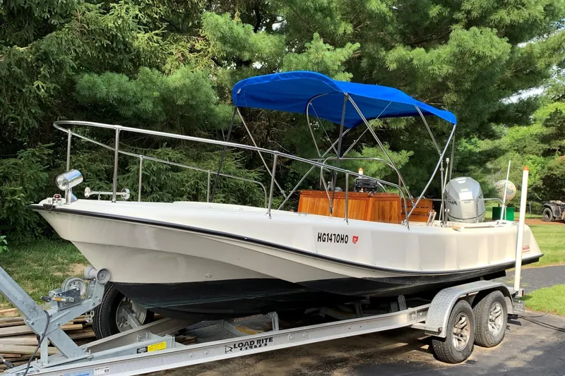 Slide: The Image of 1972 Boston Whaler Outrage Rib Side boat on trailer with blue canopy. - 4
