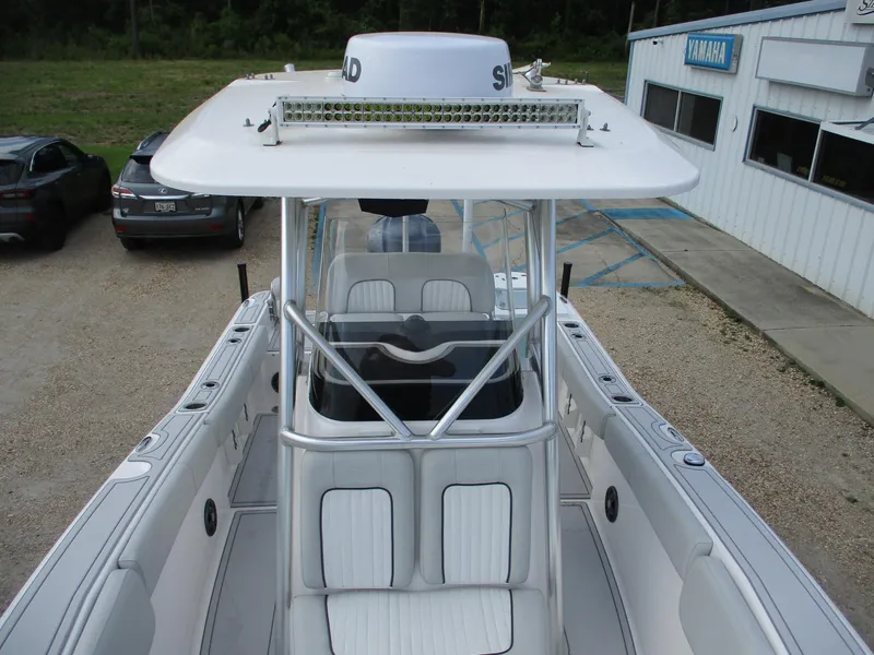 Slide: The Image of 2022 Sea Fox 228 Commander boat with T-top and seating, parked near a building. - 16