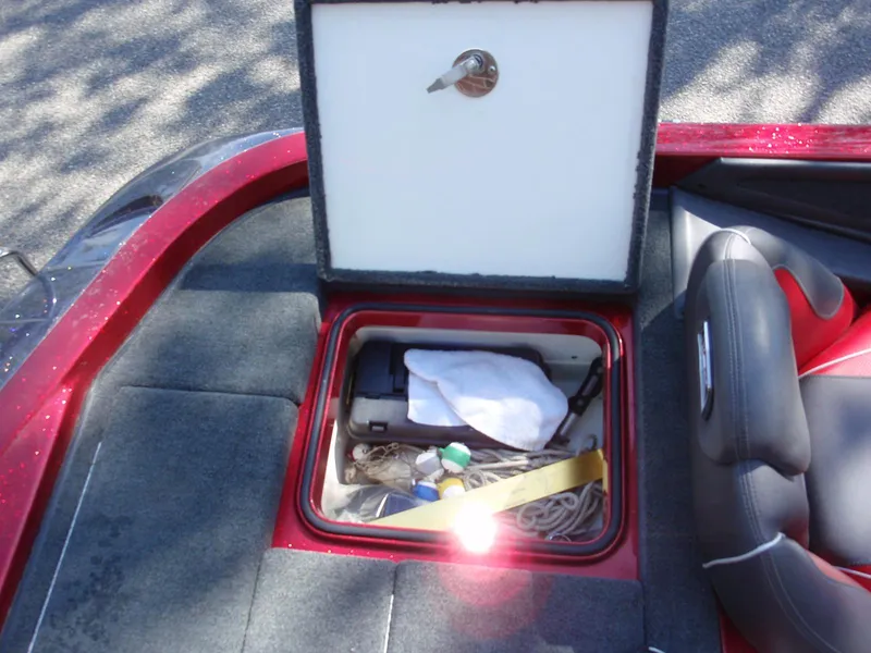 Slide: The Image of 2017 Ranger Z518 Comanche boat storage compartment with various items inside. - 16