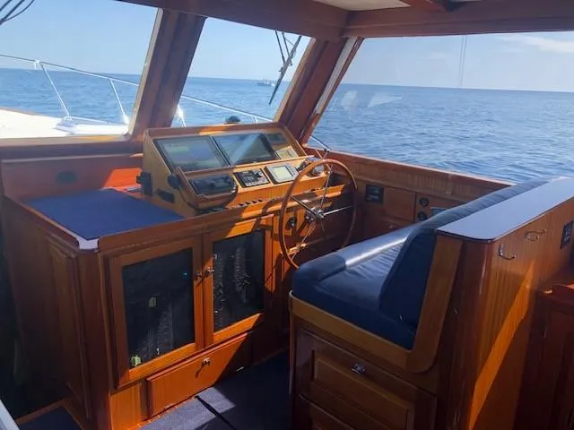 Slide: The Image of 2003 Lyman-Morse Wesmac Sportfish Cruiser helm with wooden interior, ocean view. - 1