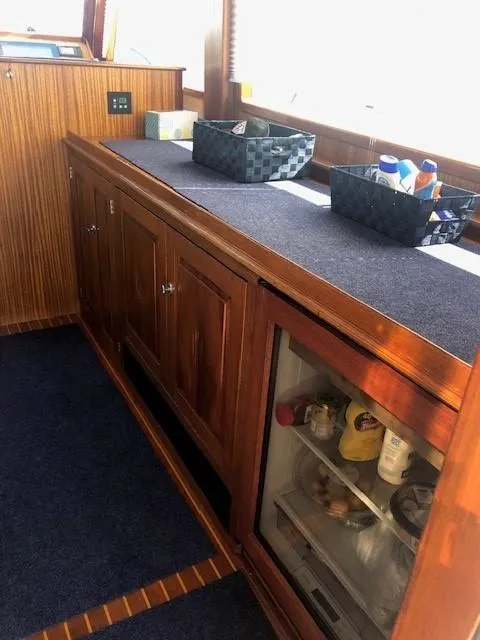 Slide: The Image of 2003 Lyman-Morse Wesmac Sportfish Cruiser interior with wooden cabinetry and mini fridge. - 12