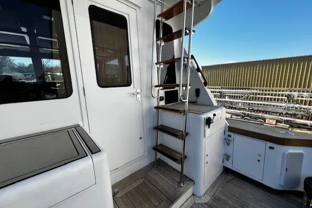 Slide: The Image of 2003 Lyman-Morse Wesmac Sportfish Cruiser deck with ladder and door, showcasing marine craftsmanship. - 29