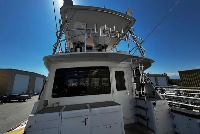 Slide: The Image of 2003 Lyman-Morse Wesmac Sportfish Cruiser, rear view, docked under clear blue sky. - 33