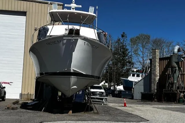 Slide: The Image of 2003 Lyman-Morse Wesmac Sportfish Cruiser on dry dock, surrounded by industrial buildings. - 34