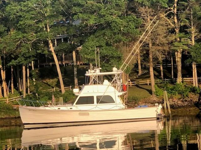 Slide: The Image of 2003 Lyman-Morse Wesmac Sportfish Cruiser docked by a wooded shoreline. - 38