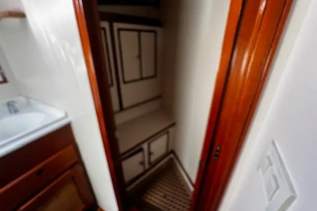 Slide: The Image of 2003 Lyman-Morse Wesmac Sportfish Cruiser interior with wooden cabinetry and compact storage space. - 45