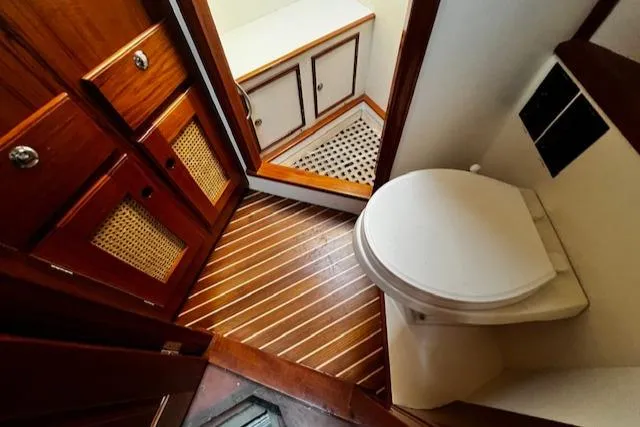 Slide: The Image of 2003 Lyman-Morse Wesmac Sportfish Cruiser bathroom with wooden cabinetry and flooring. - 46