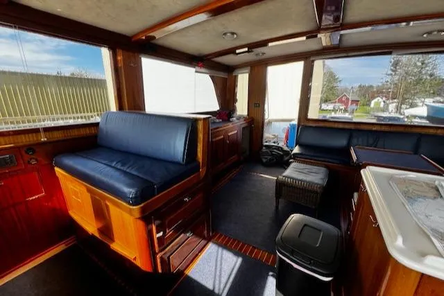 Slide: The Image of Interior of 2003 Lyman-Morse Wesmac Sportfish Cruiser with blue seating and wooden finishes. - 49