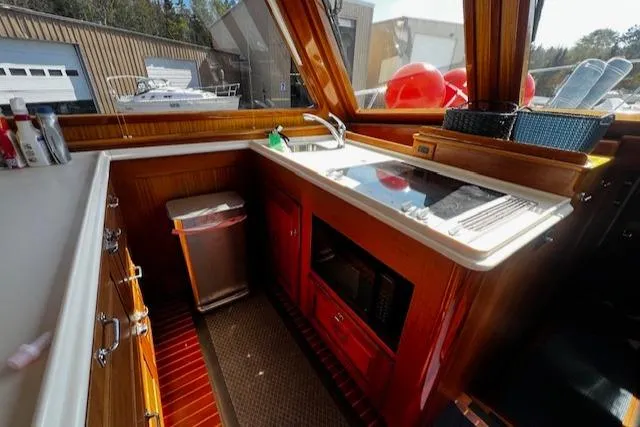 Slide: The Image of 2003 Lyman-Morse Wesmac Sportfish Cruiser kitchen with wood cabinetry and modern appliances. - 9