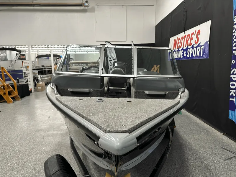 Slide: The Image of 2006 Lund 1800 Sport Angler boat displayed indoors at a marine and sport shop. - 10