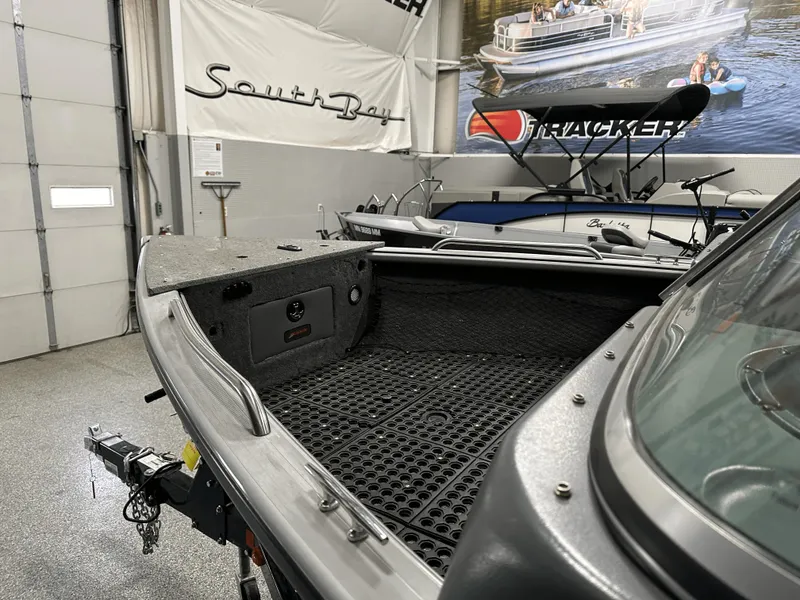 Slide: The Image of 2006 Lund 1800 Sport Angler boat interior in showroom with other boats displayed. - 16
