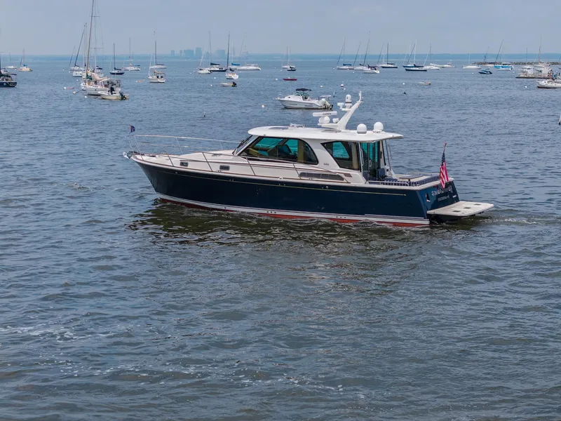 Slide: The Image of 2024 Sabre 43 Salon Express yacht cruising in a busy harbor with sailboats. - 13