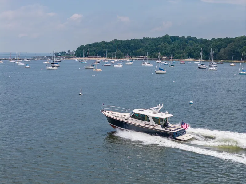 Slide: The Image of 2024 Sabre 43 Salon Express cruising in a scenic bay with numerous anchored sailboats. - 18