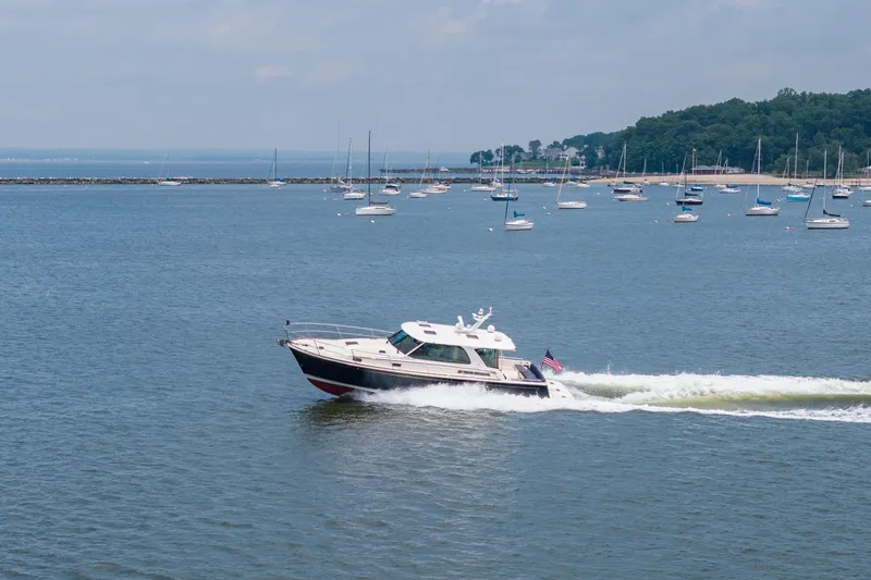 Slide: The Image of 2024 Sabre 43 Salon Express cruising on a scenic bay with sailboats in the background. - 19